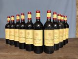 six bottles of red wine are lined up on a wooden table