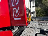a large red truck with a red and white sign on the back of it