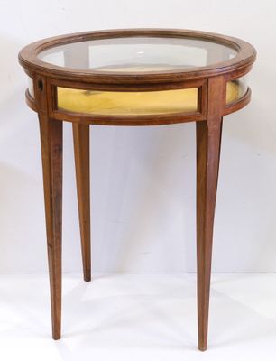 une image représentant une petite table avec un plateau en verre et des pieds en bois