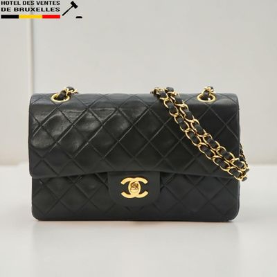 un sac Chanel noir posé sur une table blanche