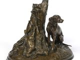 bronze statue of a dog and a cat sitting on a tree stump
