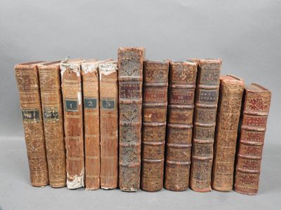 several old books are lined up in a row on a gray surface