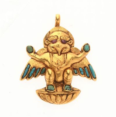 un gros plan d'un pendentif en or sur lequel figure un oiseau, vu de la tête