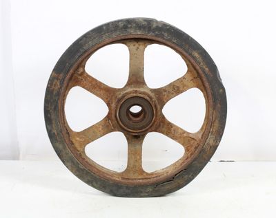an old wheel that is sitting on a white surface