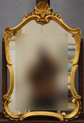 un miroir ancien dans un cadre doré, posé sur un socle en bois, avec un fond noir