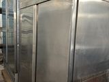 several stainless steel refrigerators are lined up in a warehouse