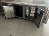 stainless steel counter top with two open doors and a glass door
