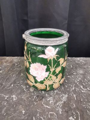un vase vert orné de fleurs roses, posé sur une table