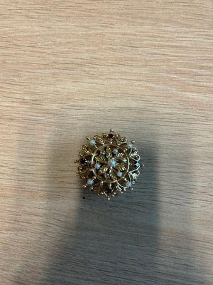 une image représentant une broche en or posée sur une table en bois