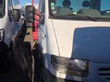 two white vans parked next to each other in a parking lot