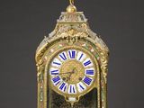 a gold clock with blue and white roman numerals on it
