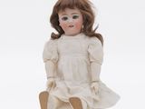 a close up of a doll sitting on a white surface