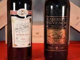 two bottles of wine sitting next to each other on a table