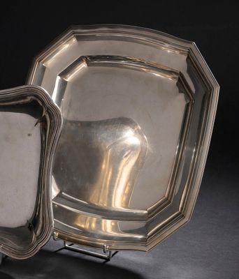deux assiettes en argent posées sur un support, sur une surface noire