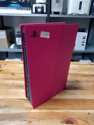 un cahier rose posé sur une table en bois devant une bibliothèque