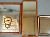 trois miroirs accrochés au mur et un miroir sur lequel est représenté un oiseau