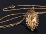 a close up of a gold necklace with a picture of a woman on it
