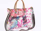 a white purse with pink flowers and a brown strap