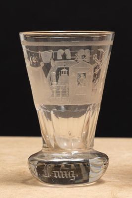 un verre à shot posé sur une table, sur fond noir