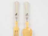 two forks and a spoon are sitting next to each other