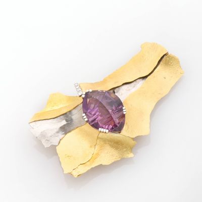 an image of a close up of a brooch with a purple stone