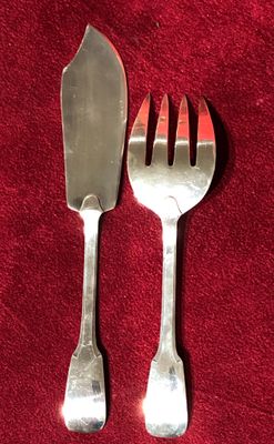 deux fourchettes et un couteau posés sur une nappe rouge