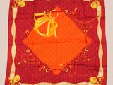 une écharpe orange et dorée ornée d'un motif monogrammé