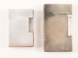 two silver lighters sitting next to each other on a white surface