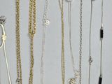many different types of necklaces and bracelets on the table