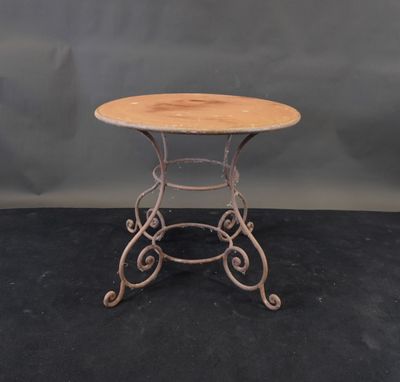 une petite table ronde avec un plateau en bois posé sur un piètement noir