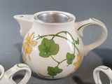 three small vases and a teapot sitting on a table