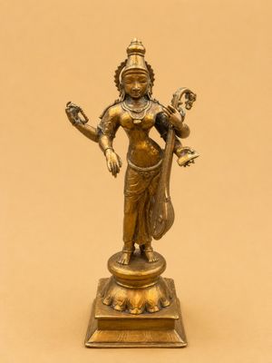 a bronze statue of a woman holding a bird on a pedestal