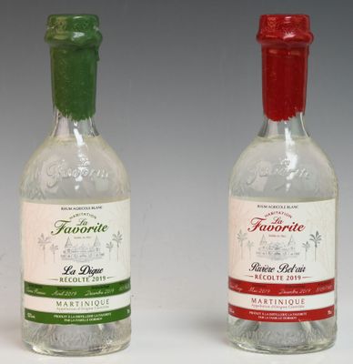 two bottles of liquor sitting next to each other on a white surface