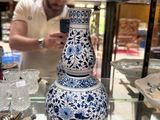 a blue and white vase on display in a glass case