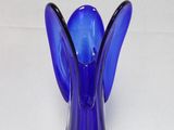 a blue glass vase with an angel on top of it