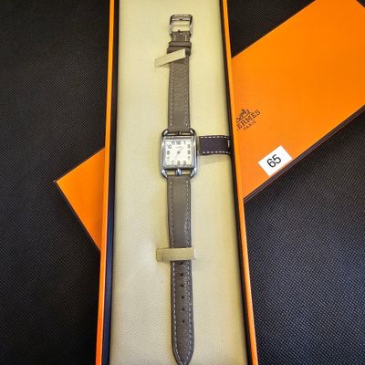 une boîte orange contenant une montre, posée sur une table