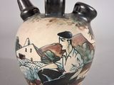 a vase with a painting on it sitting on a table