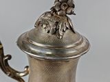 a silver coffee pot with a bird on it