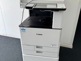 une imprimante blanche posée sur une imprimante noir et blanc