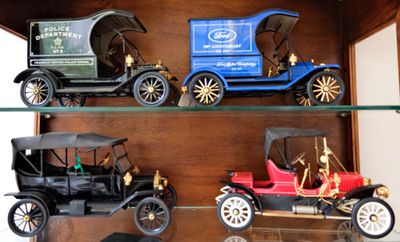 trois voitures anciennes exposées dans une vitrine