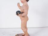 a figurine of a boy holding a ball on a wooden block