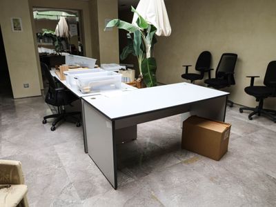 an office with a desk, chairs, and a plant in the corner