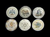 six assiettes ornées de motifs différents sur fond noir