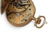 a close up of a pocket watch on a white surface