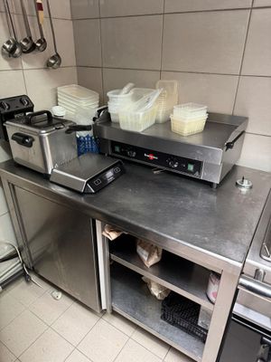 stainless steel counter top in a commercial kitchen with pots and pans on it