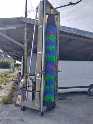 a white van parked in front of a building with a blue and green spray painted on it