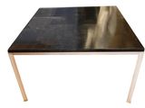 une image représentant une table avec un plateau noir et des pieds dorés