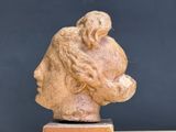a sculpture of a woman ' s head on a wooden stand