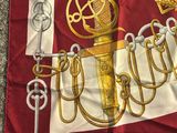 an image of a red and white scarf with gold symbols