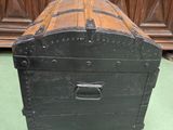 a wooden chest sitting on the floor in front of a cabinet